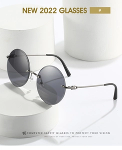 Detail of round rimless sunglasses with dark grey lenses on minimalist white pedestals