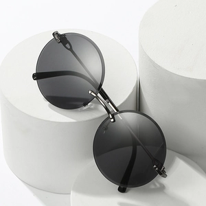 Fashionable rimless round sunglasses with dark grey lenses on white minimalist pedestals