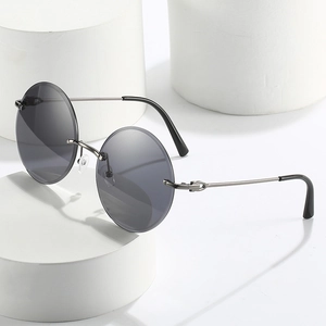Retro rimless round sunglasses with grey lenses and gunmetal frame on white stand