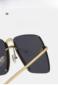 Detailed close-up of flexible gold metal hinges and dark lenses on oversized sunglasses
