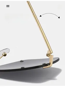 Detail of durable gold metal hinge on oversized sunglasses with dark grey lenses
