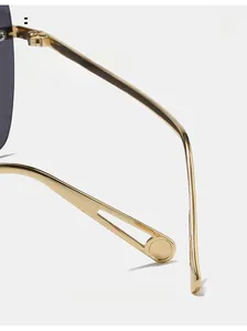 Close-up of golden curved metal temples on oversized sunglasses for comfortable wear