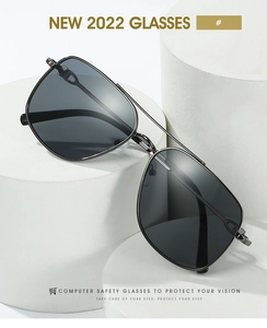 Detail view of double bridge metal aviator sunglasses on minimalist white display stand