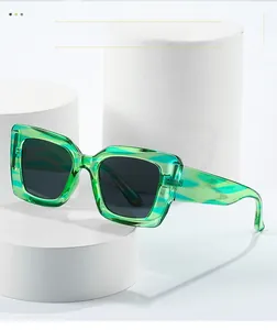 Detail of green transparent square sunglasses with black lenses on minimalist display