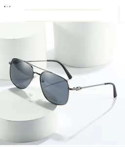 Detail of silver metal pilot sunglasses with double bridge and dark grey lenses