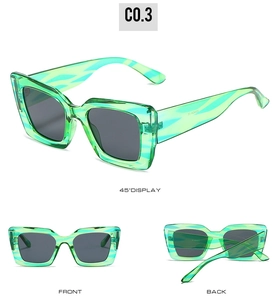 Detail view of cat eye sunglasses with green translucent marbled frame and grey lenses