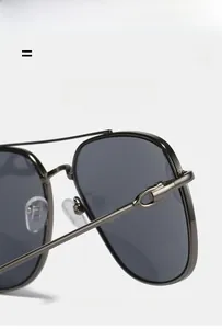 Detail of grey pilot sunglasses showing a gunmetal hinge and nose pad structure