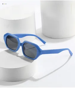 Close-up of blue geometric hexagonal sunglasses on white podium with soft shadows