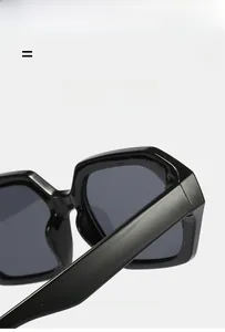 Detail of lightweight flexible hinges and glossy black frame on polygonal sunglasses