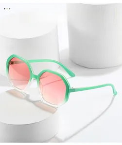 Detail of octagonal mint green frames and pink-orange gradient lenses on a pedestal