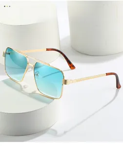Detail of gold metal double bridge frames with gradient blue lenses on white podiums