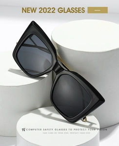 Detail of black cat-eye oversized glasses on white pedestals with metal temple view