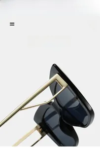 Detailed close-up of designer cat eye sunglasses with gold geometric hollow metal temples