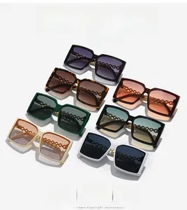 Detail showing oversized square sunglasses in seven colors with metal chain temples