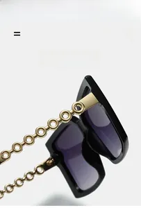 Detail of square sunglasses with golden metal chain temples and gradient lenses