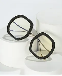 Detail of oversized square anti-blue light glasses with glitter black frame and gold metal