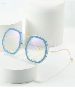 Detail of hexagonal glitter frame with blue accents and gold metal temples