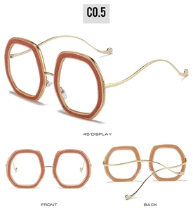 Detail view of large gold hexagonal glasses frame with shimmering pink glitter coating