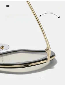 Close-up of durable golden metal hinges on large oval black optical glasses frames