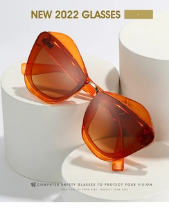 Detail of oversized orange geometric sunglasses on display stands for modern fashion