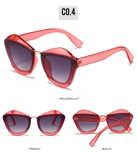 Detail view of red cat-eye sunglasses with gradient lenses and gold bridge accents