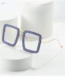 Detail of square glasses frame with blue glitter finish and slim gold metal temples