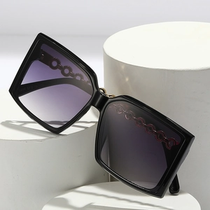 Square black sunglasses with purple gradient lenses and hollow chain temples on display