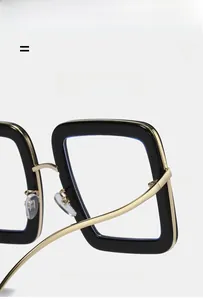 Detail of ultra-light black and gold square glasses frame showing flexible hinges
