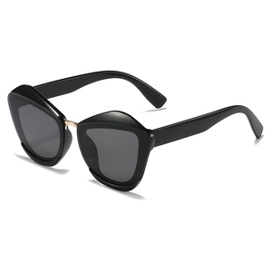 Modern black geometric cat-eye sunglasses with gold metal bridge and dark grey lenses