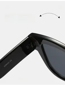 Détail macro des charnières en métal foncé sur des lunettes de soleil œil-de-chat noires