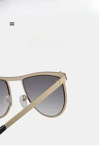 Detail of light gold metal hinge and flexible temple on geometric sunglasses