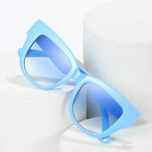 Lunettes de soleil œil-de-chat bleu clair avec verres dégradés sur socle blanc