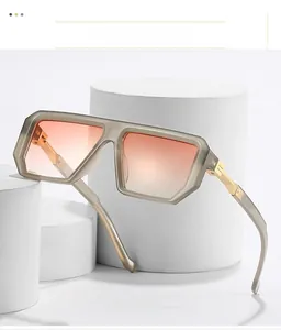 Detail of square translucent grey frame sunglasses with orange gradient lenses on white stand