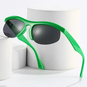 Sporty semi-rimless sunglasses in bright green with dark grey lenses on white podium