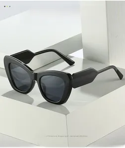 Detail of wide black resin temples on oversized cat-eye sunglasses with grey lenses