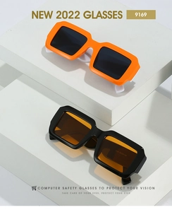 Gros plan de lunettes de soleil rectangulaires sur socle blanc montrant le numéro de modèle