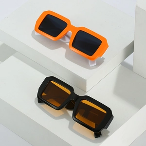 Lunettes de soleil carrées cyberpunk en orange et noir sur un support géométrique