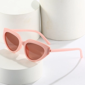 Trendy pink Y2K cat eye sunglasses with tinted lenses on minimalist white pedestals
