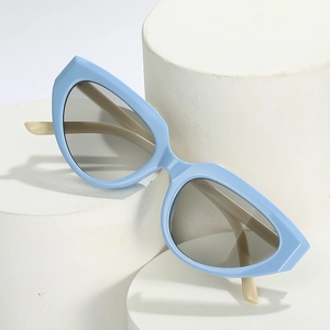 Retro Y2K cat-eye sunglasses with blue frames and beige temples on geometric stand