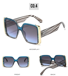 Macro detail of blue-gray gradient lenses and golden metal hinge on square sunglasses
