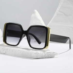 Fashionable oversized square sunglasses with black and gold metal frames and gradient lenses