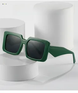 Detail view of dark green rectangle sunglasses with thick temples on white display