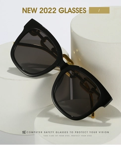 Detailed view of square black sunglasses featuring elegant gold chain link metal temples