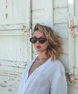Outdoor close-up of dark brown cat-eye sunglasses on a model for a chic summer look