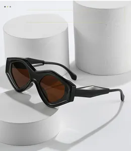 Detail view of black cat eye sunglasses with amber lenses and faceted geometric arms
