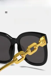 Close-up of stylish gold metal chain temples on square black oversized sunglasses