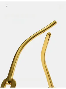 Detail of golden curved metal temple arms showing polished finish and ergonomic design