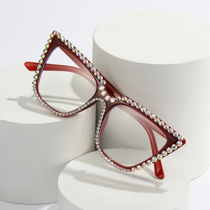 Chic cat eye sunglasses in dark red with rhinestones on white display pedestals