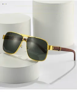 Detail of luxury pilot sunglasses with gold metal frame and reddish wood grain temples