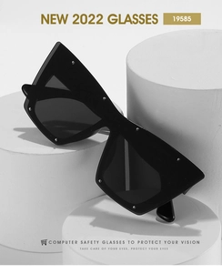Close-up of black oversized cat eye sunglasses with silver rivets on geometric frames